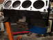 1962 Ford Thunderbird - Close-up view of an engine block supported by an orange engine stand in a workshop.