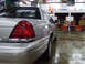 2004 Ford Crown Victoria - Rear quarter view of a silver sedan parked indoors, with fire station equipment visible in the background.