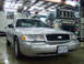 2004 Ford Crown Victoria - A silver 2004 Ford Crown Victoria is parked in a garage with fire trucks in the background.