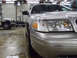 2004 Ford Crown Victoria - Front corner of a silver 2004 Ford Crown Victoria parked in a garage with another vehicle.