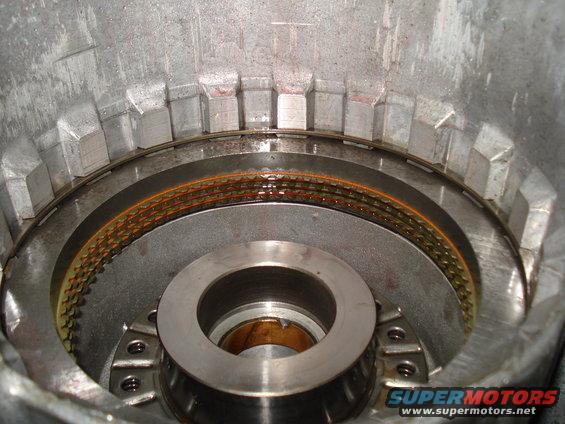 Close-up of a transmission clutch pack with worn friction material inside a metal housing