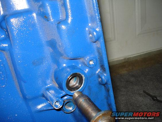 Blue engine block part with a bearing and a metal shaft inserted
