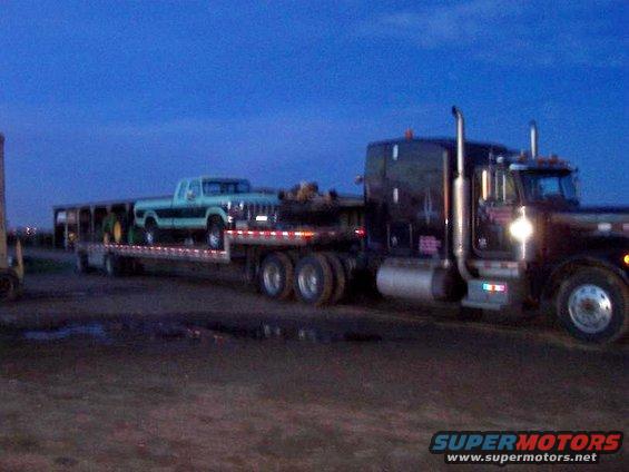 Light blue Ford F-Series pickup truck on a flatbed trailer