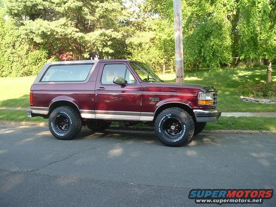 Maroon 1996 Ford Bronco parked on asphalt street, side view