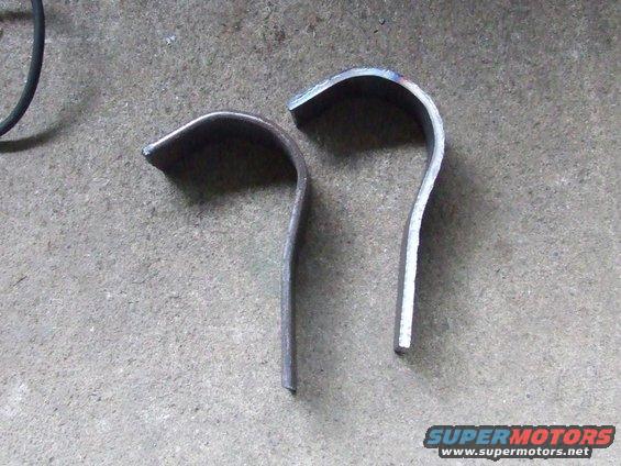 Two bent metal pieces on concrete floor