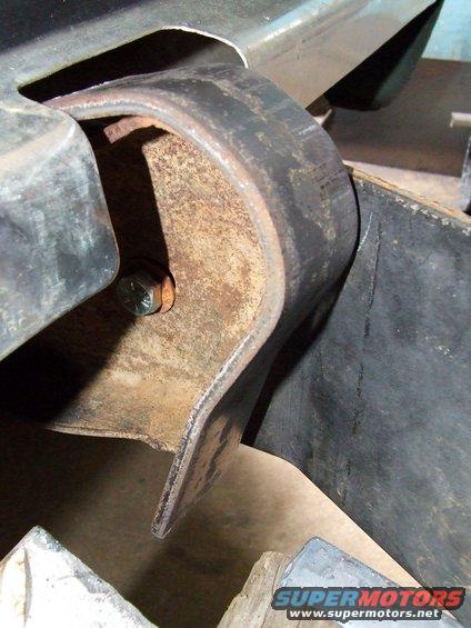 close-up of rusty metal bracket bolted to vehicle frame