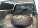 1978 Ford Bronco - The interior of a vehicle is shown, with a large spare tire taking up most of the cargo area.