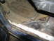 1978 Ford Bronco - The interior floor of the vehicle shows significant wear and tear, with a rubber mat over carpet and visible rust on the metal.