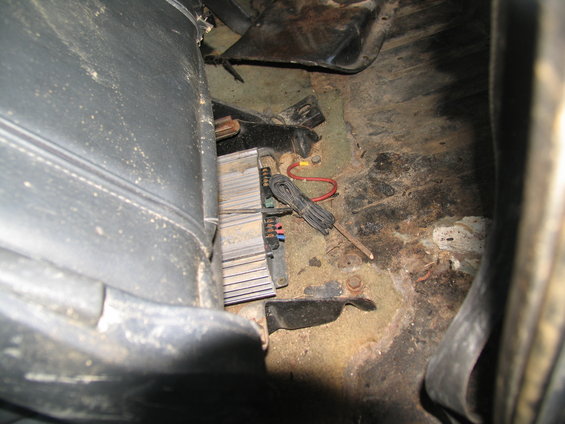 Vehicle interior with amplifier and wiring visible near the seat