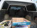 1978 Ford Bronco - The interior of a white SUV is visible, showing black seats and a cardboard box in the cargo area.