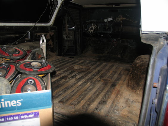 Interior of a 1978 Ford Bronco with a box of speakers and a worn dashboard
