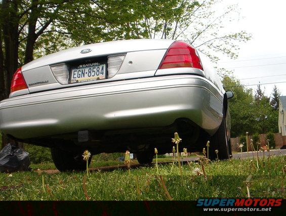Rear view of a silver 2003 Ford Crown Victoria parked in a grassy area