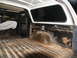 1978 Ford Bronco - The interior of an older SUV shows significant wear and tear, with rust visible on the wheel wells and a ribbed cargo floor.