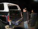1978 Ford Bronco - A woman pressure washes the interior of a 1978 Ford Bronco's tailgate area at night.