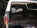 1978 Ford Bronco - Rear view of a 1978 Ford Bronco showing the cargo bed and interior, with another vehicle visible.