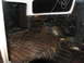 1978 Ford Bronco - The cargo area of the vehicle shows significant rust and wear on its floor and wheel wells.