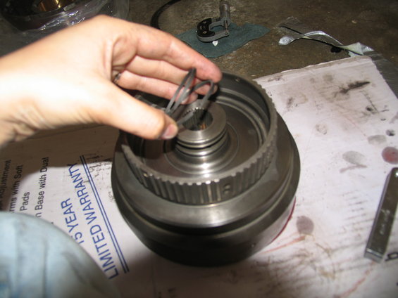hand holding metal rings over a transmission component