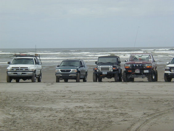 Dark green SUV on beach, front view. Likely a 1998 Ford Explorer