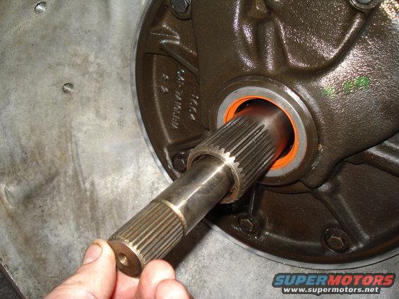 Splined shaft being inserted into a transmission housing with an orange seal
