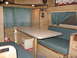 1971 Ford E350 - Interior view of a camper van, a fold-down table and bench seating.