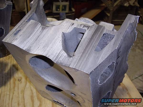 Cut engine block part with internal cavities and rough edges, on a wooden surface