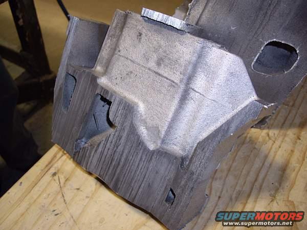 Metal engine part on wooden surface. Supermotors.net logo visible