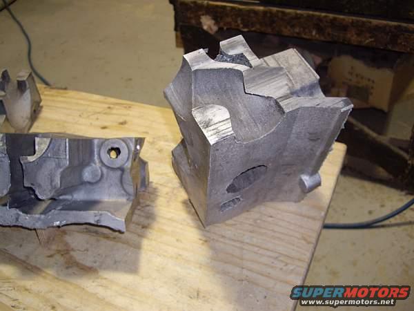 Two cast iron engine block sections on a wooden surface