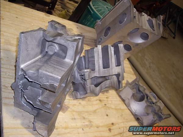 Broken engine block pieces on a wooden surface