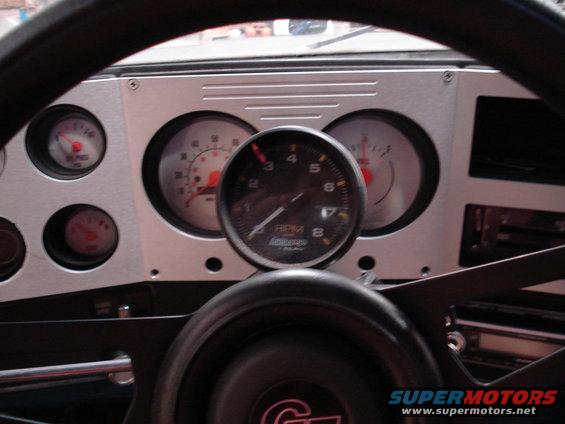 Dashboard interior with tachometer, speedometer, oil pressure, and temperature gauges. Aftermarket gauges are installed