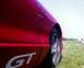 1993 Ford Probe - A close-up of a red car's side panel reveals a 'GT' decal and a portion of the wheel.