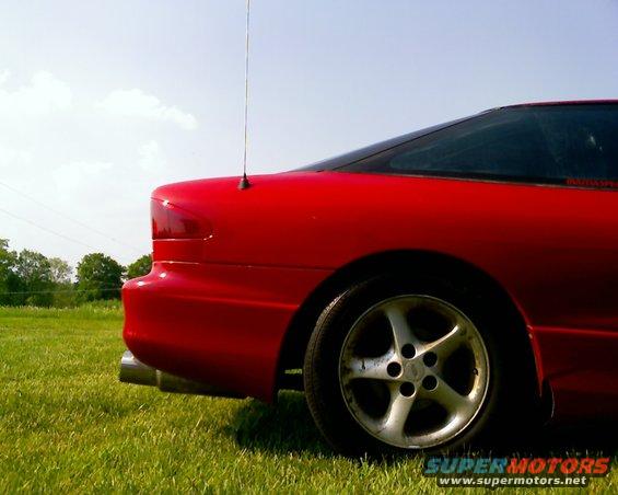 Red 1993 Ford Probe rear quarter panel and wheel, parked on grass