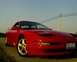 1993 Ford Probe - A red 1993 Ford Probe GT is shown from a 3/4 front view, gold five-spoke wheels and a clear blue sky.