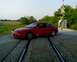 1993 Ford Probe - A red 1993 Ford Probe GT is positioned on railroad tracks with a crossing signal in the background.