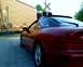 1993 Ford Probe - A red coupe waits at a railroad crossing as a train passes by.
