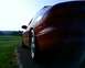 1993 Ford Probe - The rear quarter panel and taillight of a red sports coupe are visible against a bright sky.
