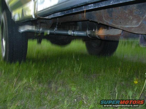 underneath a vehicle showing the exhaust pipe and muffler
