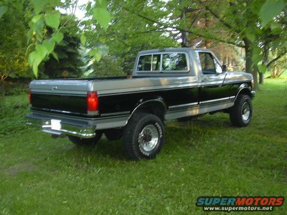 Two-tone pickup truck, rear 3/4 view. Silver and black