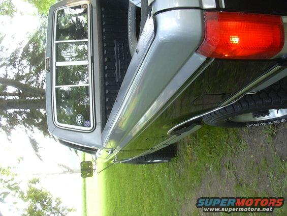 Silver and black Ford F-250 truck, rear quarter panel and bed visible, with a red taillight