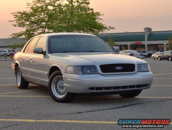 Silver 2002 Ford Crown Victoria sedan parked in a lot, front 3/4 view