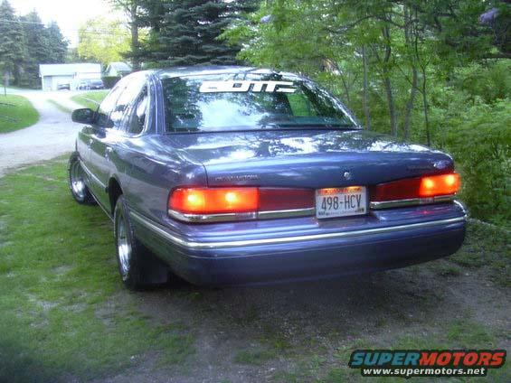 1996 Ford Crown Victoria rear view, parked on grass near trees. License plate 498-HCV