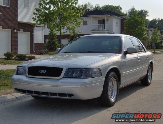 Silver 2002 Ford Crown Victoria sedan, front 3/4 view, parked on a suburban street