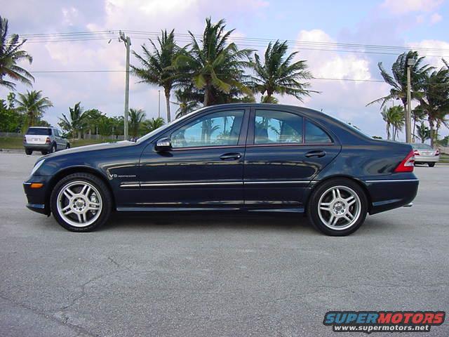 Dark blue 2002 Mercedes-Benz C-Class sedan parked, side view. Another SUV and car in background