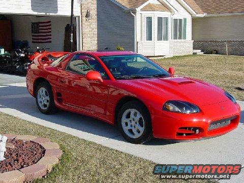 Red sports car parked in driveway, American flag visible in garage