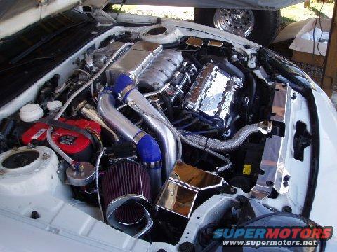 Engine bay with chrome supercharger, red battery, and aftermarket air filter