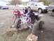 2005 Honda TRX 450 R - Two ATVs are parked on rocky terrain, with a black Honda TRX 450 R in the foreground.