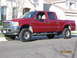 2004 Ford F-250 - This red 2004 Ford F-250 crew cab pickup truck is shown from the front three-quarter view.