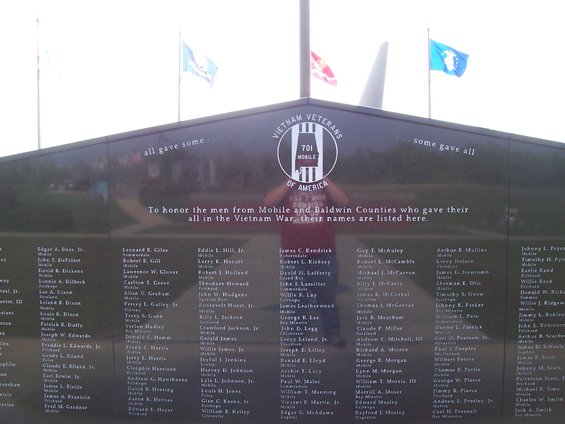 Vietnam Veterans Memorial wall with names and flags