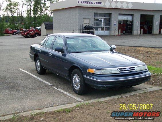 Dark blue Ford Crown Victoria parked outside an Express Lube service station