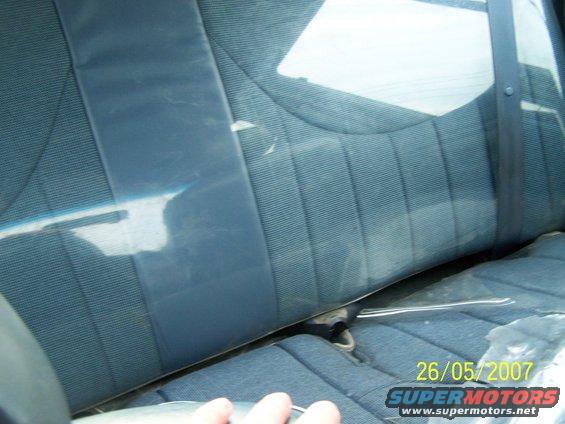 Interior rear seat with blue fabric upholstery and a seatbelt