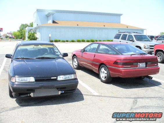 1991 Ford Probe and a black Mazda parked side-by-side in a parking lot